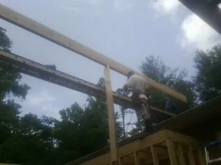 Carpenter setting a ridge beam over a new addition frame — Ice Dam Removal by Roofing Brothers in Bolton