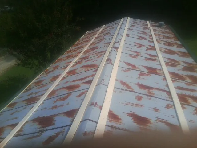 Rusted metal roof panels with new wood purlins before replacement — Storm Damage Roof Repair in Bolton by Roofing Brothers