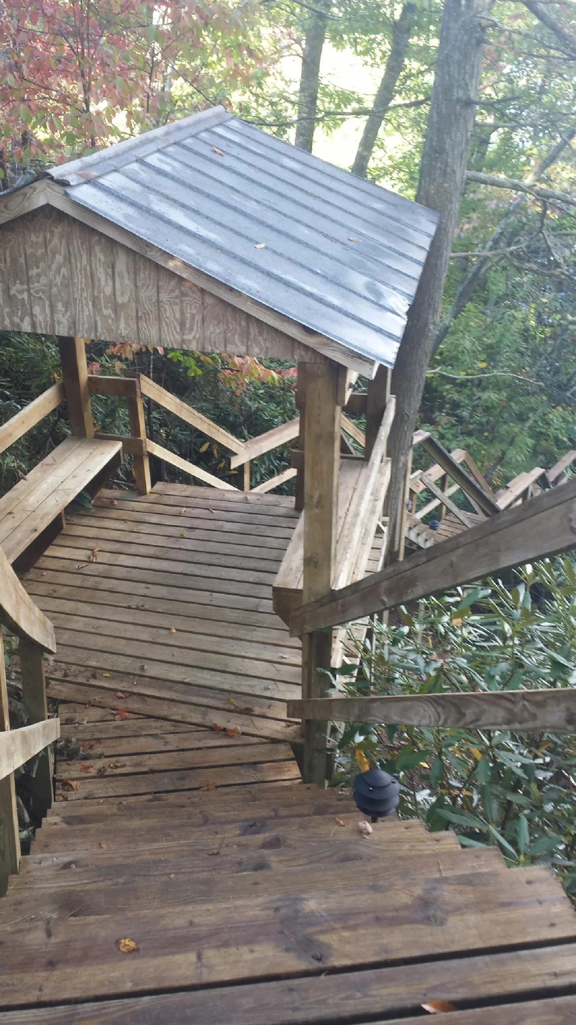 Metal roofed shelter over wooden steps on a wooded walkway — Skylight Repair & Installation work by our crew in Bolton