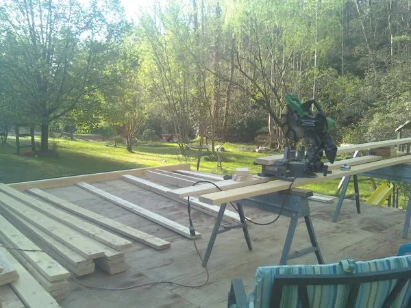 Miter saw and framing lumber on a deck under construction in Bolton
